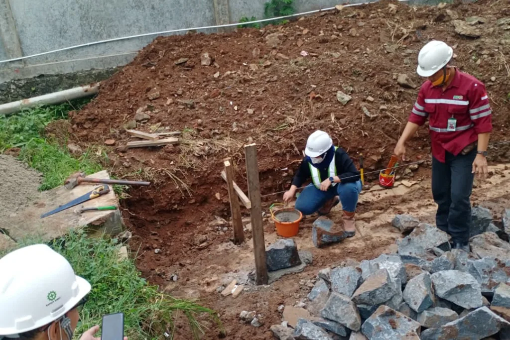 Sinar Alam Cakrabuana Worker Installing the First Stone for Rain Water Absorption Facility